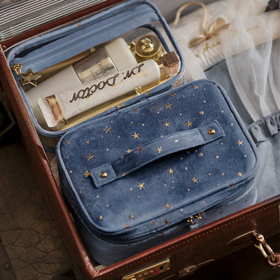 Blue star print velvet travel makeup bag with handle and bottles inside washable beauty product case