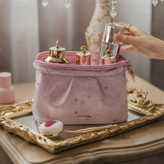 Pink velvet star print washable beauty product case on ornate mirrored tray holding perfume bottles
